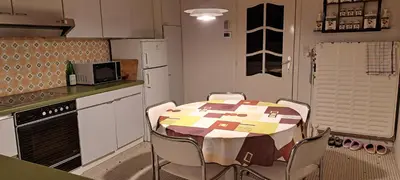 a kitchen with a table and chairs in a kitchen at A home away from home in Oudsbergen