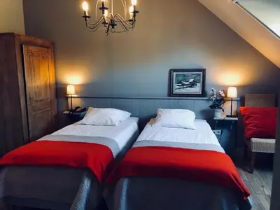 two beds sitting next to each other in a room at B&B Het Welthof in Bree