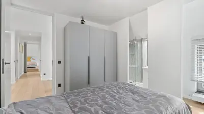 a bedroom with a bed and a white cabinet at Maison Quatre-Vingt-Deux in Maasmechelen