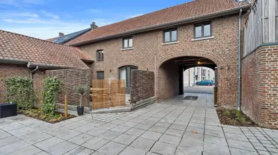 an entrance to a brick building with a driveway at Maison Quatre-Vingt-Deux in Maasmechelen