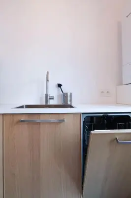 a kitchen with a sink and wooden cabinets at 1 bedroom apartment in Liège center - 3rd floor in Liège