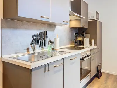 a kitchen with white cabinets and a sink at Angleur Appartement 001 rez arrière in Liège