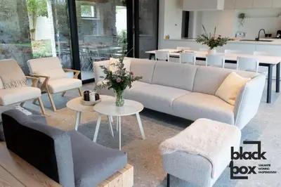 a living room with a couch and chairs and tables at Black Box by De Schrijfbar - vakantiewoning Haspengouw in Wellen