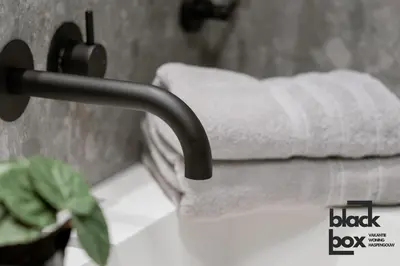 a towel dispenser on a sink in a bathroom at Black Box by De Schrijfbar - vakantiewoning Haspengouw in Wellen