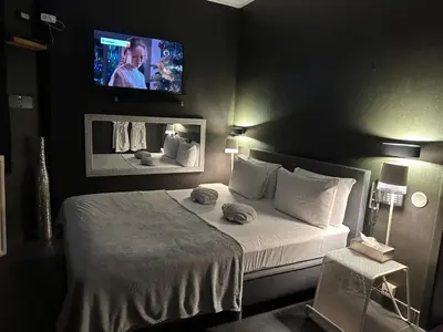 a bedroom with a bed with a tv on the wall at lelysblanc in Liège