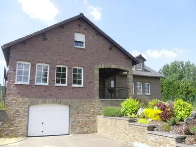 a brick house with a white garage at Eaglenest in Baelen