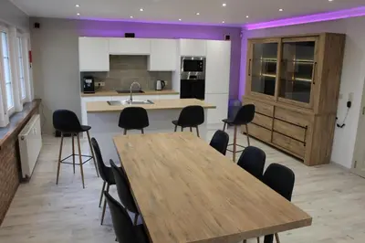 a kitchen with a wooden table and black chairs at Eaglenest in Baelen