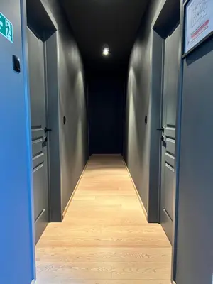 a hallway with two doors and a wooden floor at De Boomgaard Voeren in Voeren