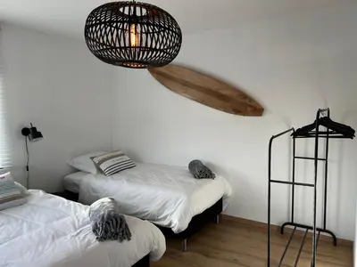 a bedroom with two beds and a chandelier at De Boomgaard Voeren in Voeren