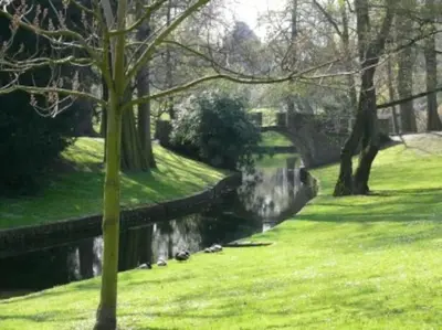 a bridge over a river in a park at Angleur Appartement 011 1er étage avant cosy in Liège