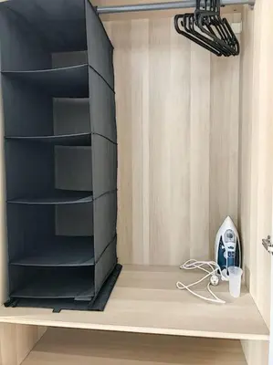 a closet with a black book shelf with a fan at Angleur Appartement 011 1er étage avant cosy in Liège