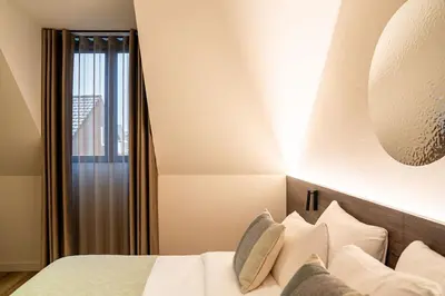 a bedroom with a bed with white pillows and a window at Boutique Hotel Annamaes, Maastricht-Hoge Kempen in Lanaken