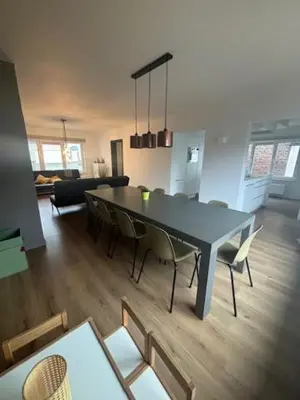 a dining room and living room with a table and chairs at La Redoute in Tongeren