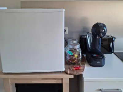 a white refrigerator sitting on a table next to a blender at La Vie en Rose in Verviers