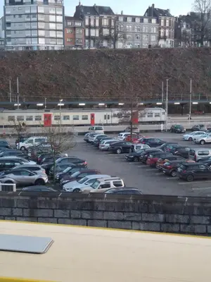 a parking lot full of cars with a train at La Vie en Rose in Verviers