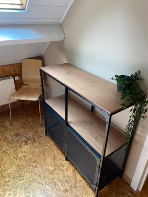 a shelf in a room with a table and a chair at Hengelhoef Ceder 106 in Houthalen-Helchteren