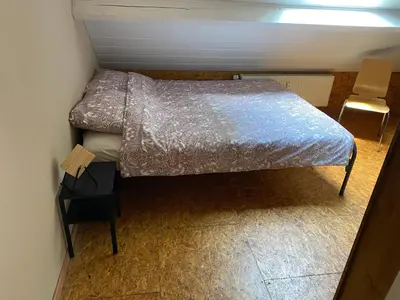a small bedroom with a bed and a chair at Hengelhoef Ceder 106 in Houthalen-Helchteren