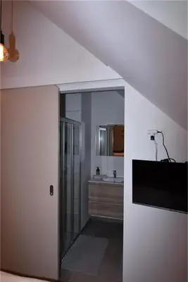 a white room with a hallway with a sink and a room with at B & B 't Pomphuys in Zoutleeuw