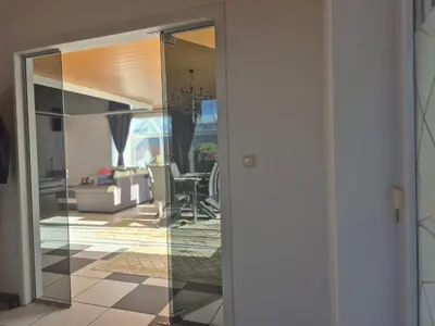 a view of a living room through a glass door at Afgelegen woning met buitenjacuzzi en vergaderruimte ! in Pelt