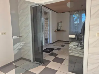 a glass elevator in a room with a tiled floor at Afgelegen woning met buitenjacuzzi en vergaderruimte ! in Pelt