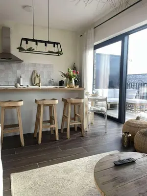 a living room with a kitchen with stools and a table at Casa Lariz in Hasselt