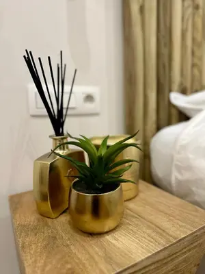 three gold vases sitting on a table with a plant at Appartement cosy à Liège in Liège
