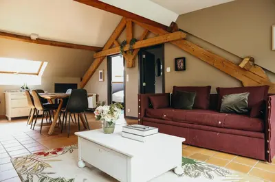 a living room with a red couch and a table at L'Air du Pré by WelcHome in Verviers