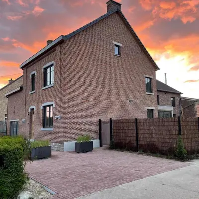 a brick building with a fence in front of it at Villa Victoire in Heers
