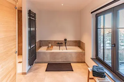 a bath tub in a room with a large window at Villa Victoire in Heers