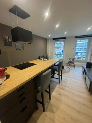 a kitchen with a long counter and chairs in a room at Magnifique appartement 1 chambre in Liège