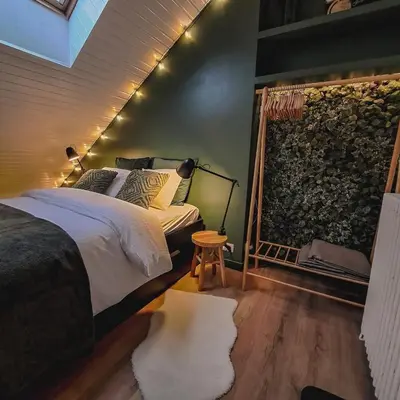 a bedroom with a bed and a stone wall at Chambre et salle de bain privative in Liège