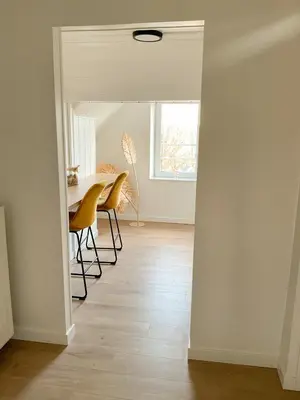 a dining room with a table and chairs and a window at Chambre et salle de bain privative in Liège