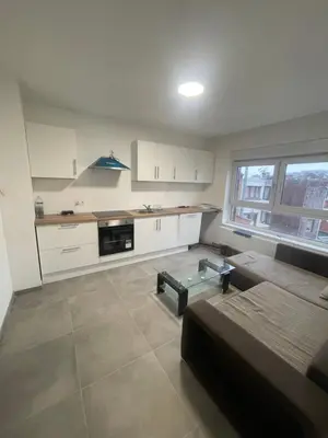 a kitchen with a couch and a table in a room at Sterna in Liège