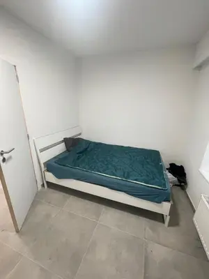 a bedroom with a bed in a white room at Sterna in Liège