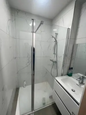 a white bathroom with a shower and a sink at Sterna in Liège