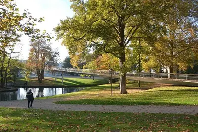 a person walking in a park next to a bridge at Appartement 002 au rez-de-chaussée avant in Angleur