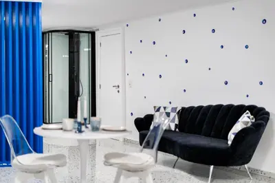 a living room with a black couch and two chairs at Loft36 in Herstal