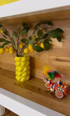 a wooden shelf with a yellow vase and a toy at Loft36 in Herstal