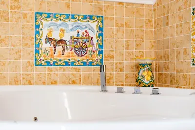 a bathroom with a tile wall with a picture of a horse and carriage at Loft36 in Herstal