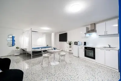 a kitchen with white cabinets and a table and chairs at Loft36 in Herstal