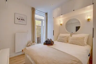 a bedroom with a large bed with a mirror at - Suite Solvay - Cosy & Modern Flat in Liège