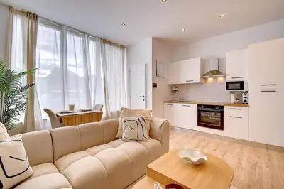 a living room with a couch and a kitchen at - Suite Solvay - Cosy & Modern Flat in Liège