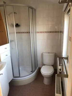 a bathroom with a shower and a toilet and a sink at Chalet nr 17 Park Bergzicht Teuven in Voeren