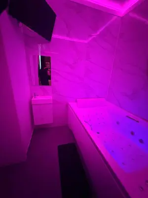 a pink room with a person in a mirror at La Suite White wellness Jacuzzi & Sauna in Seraing