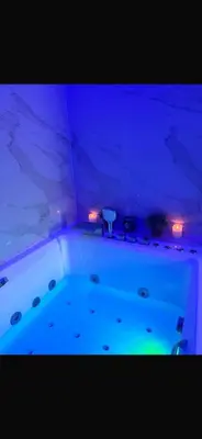 a bath tub with blue lights in a room at La Suite White wellness Jacuzzi & Sauna in Seraing