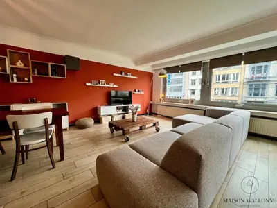 a living room with a couch and a table at L 'écrin sauvenière - Hypercentre avec Parking gratuit in Liège