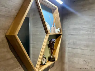 a mirror on a wall with a vase on a shelf at L 'écrin sauvenière - Hypercentre avec Parking gratuit in Liège