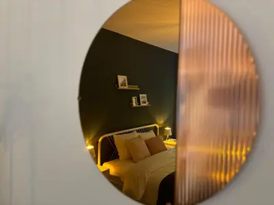 a mirror reflection of a bed in a bedroom at L 'écrin sauvenière - Hypercentre avec Parking gratuit in Liège