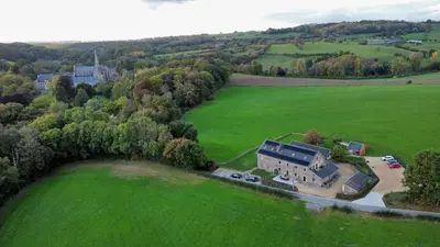 an aerial view of a large house in a green field at La Bushaye in Aubel