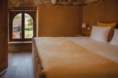 a bedroom with a large bed and a window at La Bushaye in Aubel